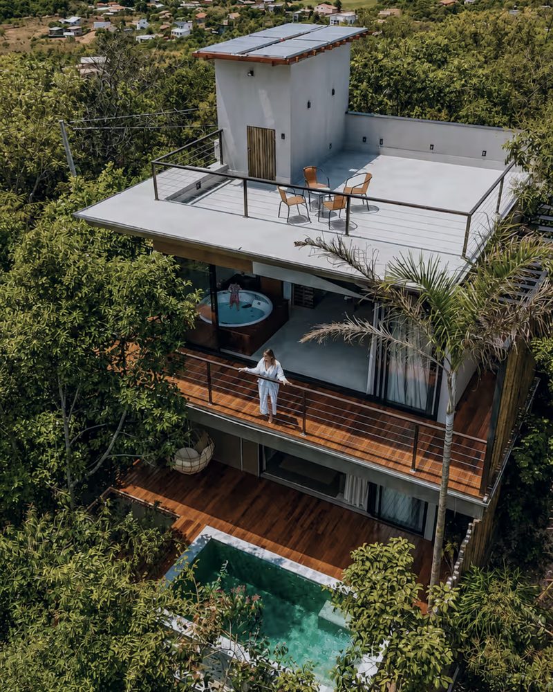 Bangalô Abraço visto do alto: rooftop, varanda com jacuzzi e a piscina no nível do deck, cercado pela mata
